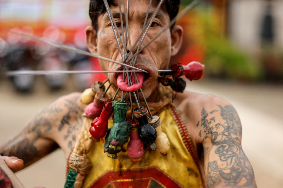 <p>Este hombre con un sinfín de agujas clavadas en la lengua y el alrededor de la boca es uno de los devotos taoístas que participa en una procesión del Festival Vegetariano, un evento religioso que tiene lugar en la isla tailandesa de Phuket. (Foto: Jorge Silva / Reuters).</p> 