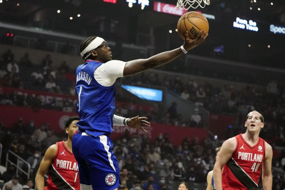 Clippers guard Reggie Jackson scores in front of Trail Blazers players