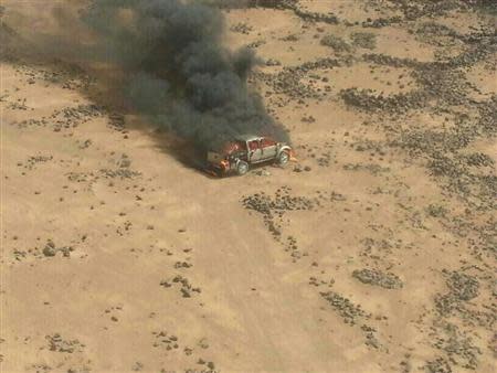 Handout photo of a pickup truck on fire after it was hit by a Jordanian warplane following failure to heed warnings not to cross into Jordan from Syria April 16, 2014. REUTERS/www.ammonnews.net/Handout via Reuters