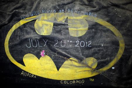 A Batman logo is covered in dirt left at the memorial for victims of the movie theater shooting in Aurora July 25, 2012. REUTERS/Rick Wilking