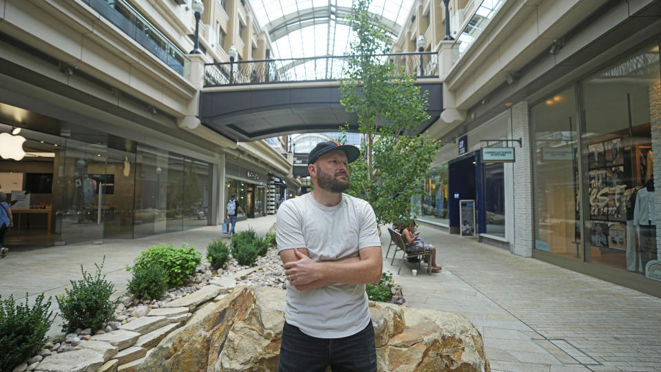 Jake Welch stands in open-air shopping center, Wednesday, Aug. 2, 2023, in Salt Lake City. The 36-year-old brand director for an advertising firm calculates the cost-per-wear of his wardrobe by highlighting 200 items in a spreadsheet — excluding underwear and socks — and meticulously listing the price he paid for each of them as well as how many times he's worn it. (AP Photo/Rick Bowmer)