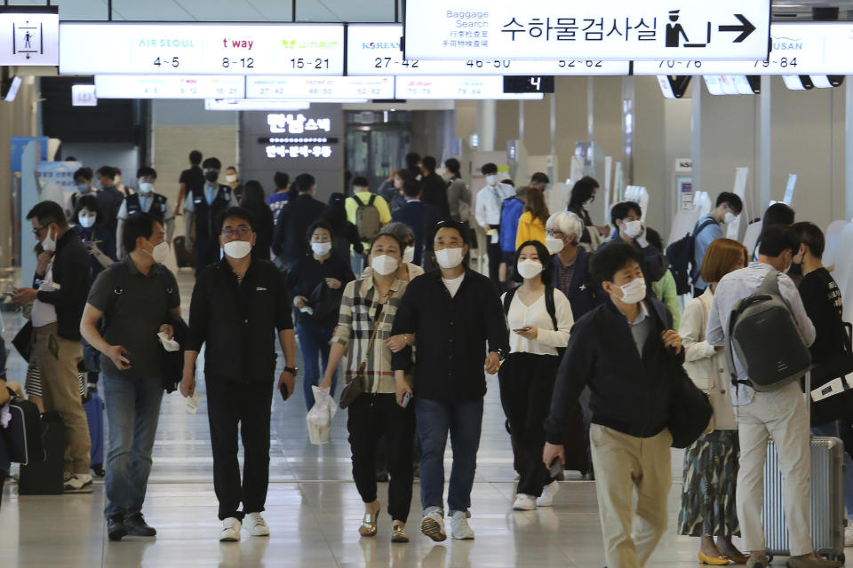 People wearing face masks arrive at the domestic flight terminal of Gimpo airport in Seoul, South Korea, Wednesday, May 27, 2020. The quarantine authorities on Wednesday began to require all airplane passengers to wear masks amid the coronavirus pandemic. (AP Photo/Ahn Young-joon)