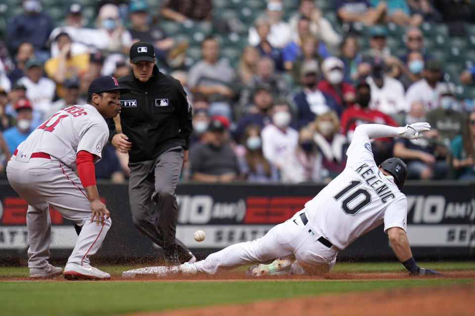 Seattle Mariners' Jarred Kelenic (10) slides safely into third base as Boston Red Sox third baseman Rafael Devers waits for the ball in the third inning of a baseball game Wednesday, Sept. 15, 2021, in Seattle. Boston right fielder Hunter Renfroe was charged with a throwing error on the play and Kelenic scored. (AP Photo/Elaine Thompson)