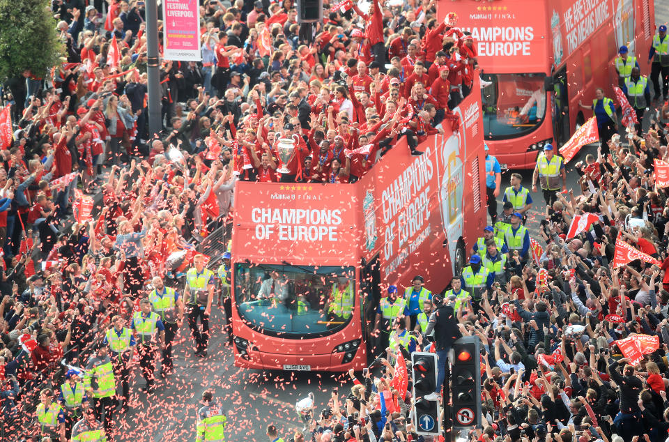 Liverpool players and staff on the bus pass the crowd of fans gathered on the route during the Champions League Winners Parade in Liverpool.