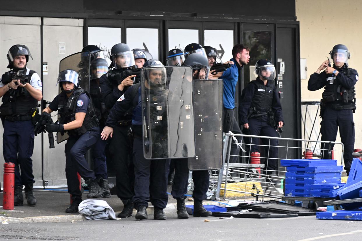 Police officers detain a protester (R) and stand guard in front of Rosny 2 in Rosny-sous-Bois (AFP via Getty Images)