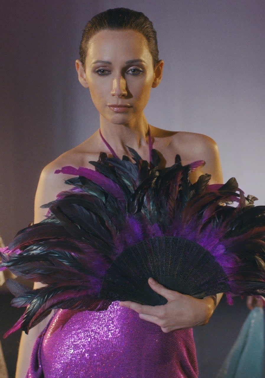 Rebecca Dayan in Halston with a large feather hand-held fan