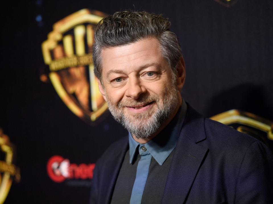 Andy Serkis wearing a black suit in front of a black background