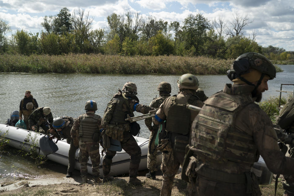 Ukrainian servicemen unload a boat in the retaken village of Shchurove, Ukraine.
