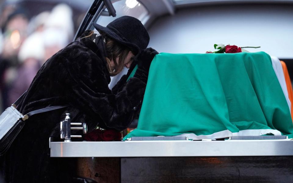 Star's wife Victoria Clarke greets the coffin as it arrives at church funeral in Nenagh