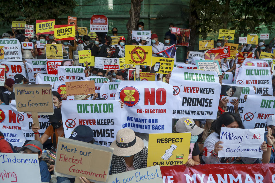 Anti-coup protesters display placards near the Indonesian Embassy in Yangon, Myanmar, Wednesday, Feb. 24, 2021. Anti-coup protesters gathered outside the Indonesian Embassy following reports that Indonesia was seeking to have fellow members of the Association of Southeast Asian Nations to agree on an action over the Myanmar's coup that would hold the junta to its promise to hold free and fair elections in a year's time. The Indonesia Foreign Ministry has denied the report. (AP Photo)