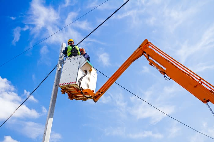 An engineer works on an electric wire.