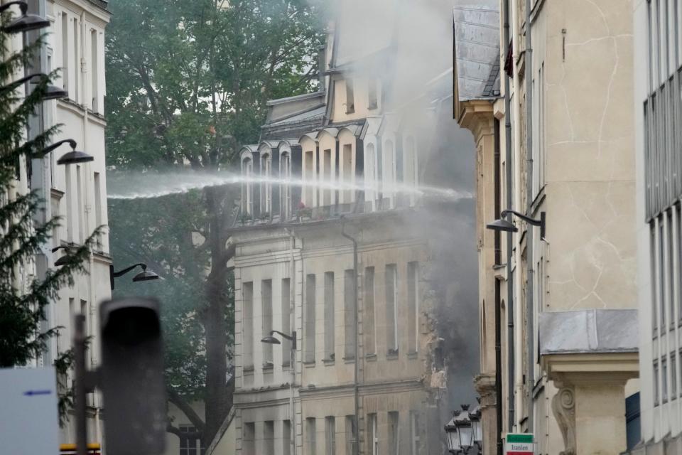 Firemen use a water canon as they fight a blaze Wednesday, June 21, 2023 in Paris. Firefighters fought a blaze on Paris' Left Bank that is sent smoke soaring over the domed Pantheon monument and prompted evacuation of buildings in the neighborhood, police said. Local media cited witnesses describing a large explosion preceding the fire, and saying that part of a building collapsed.