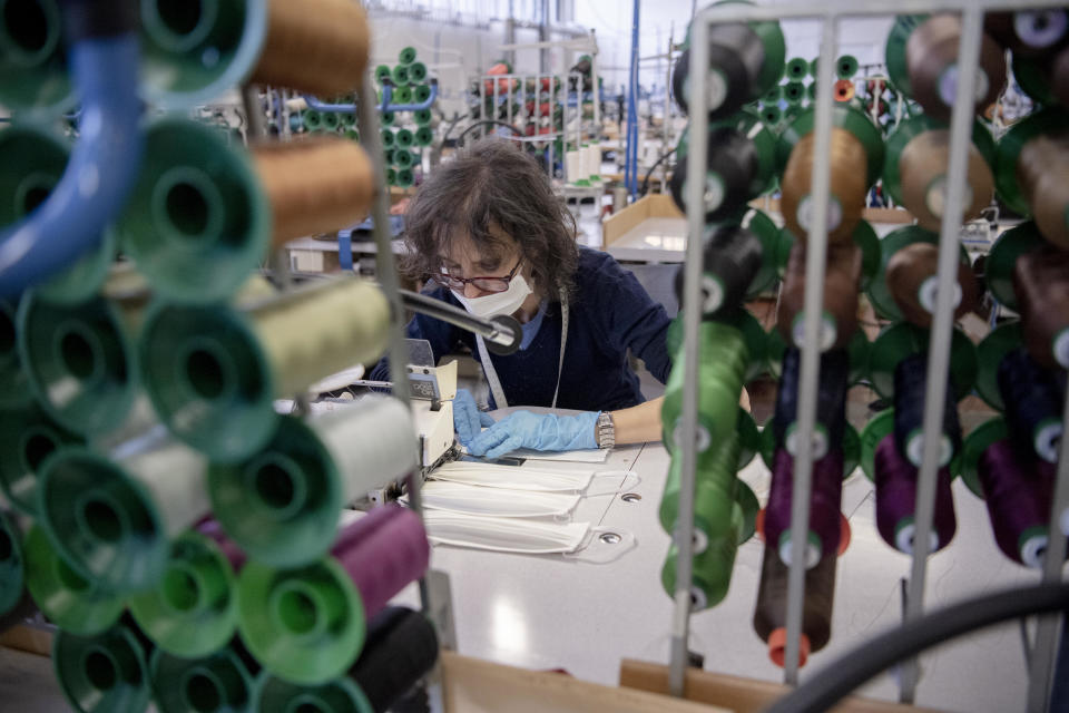 An employee works to produce face masks in the Miroglio group factory in Alba, Northern Italy, Tuesday, March 17, 2020. In order to face the coronavirus emergency, the factory was converted to the production of masks. For most people, the new coronavirus causes only mild or moderate symptoms. For some it can cause more severe illness, especially in older adults and people with existing health problems. (Marco Alpozzi/LaPresse via AP)