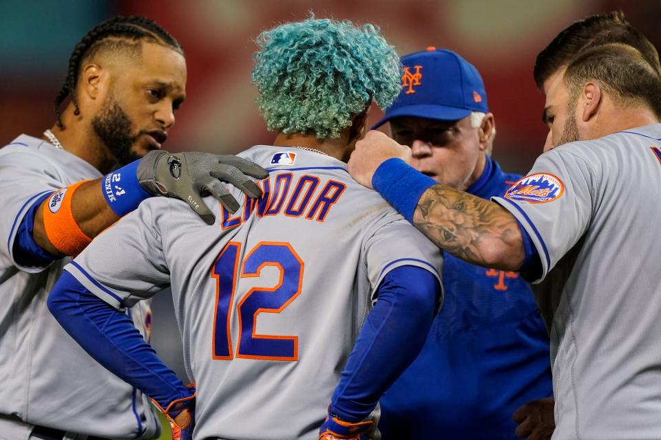 New York Mets shortstop Francisco Lindor (12) is checked by teammates and manager Buck Showalter, second from right, after he was hit by a pitch during the fifth inning of a baseball game against the Washington Nationals at Nationals Park, Friday, April 8, 2022, in Washington. (AP Photo/Alex Brandon)