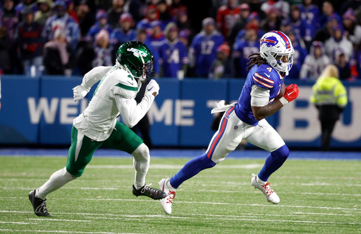 Buffalo Bills running back James Cook (4) races to the outside against New York Jets cornerback D.J. Reed (4).