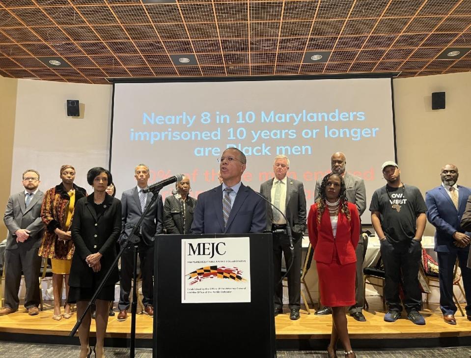 Maryland Attorney General Brown, at lectern, speaks during an Oct. 25, 2023 press conference announcing the Maryland Equitable Justice Collaborative while Bowe State University President Aminta Breaux, stands at left, and Maryland Public Defender Natasha Dartigue, stands at right, with collaborative members on stage behind. “We will end the seemingly nonstop, unrelenting mass incarceration of Black men and women in Maryland,” said Brown, in an auditorium on the campus of Bowie State University, the state’s oldest Historically Black College or University, established in 1865 before the end of either the Civil War or the institution of slavery.