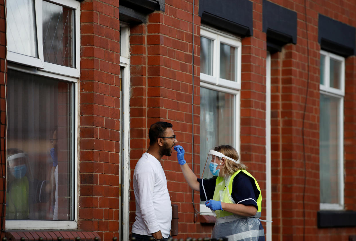 A member of the community swabbing team carries out a doorstep COVID-19 test following the outbreak of the coronavirus disease (COVID-19) in Chadderton, Britain, October 1, 2020. Picture taken October 1, 2020.   To match Special Report HEALTH-CORONAVIRUS/BRITAIN-NEWWAVE  REUTERS/Phil Noble