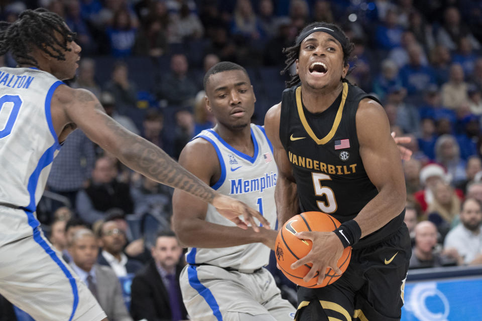 Vanderbilt guard Ezra Manjon (5) drives against Memphis guards Jakwon Walton (10) and Jayhlon Young (1) during the second half of an NCAA college basketball game Saturday, Dec. 23, 2023, in Memphis, Tenn. (AP Photo/Nikki Boertman)