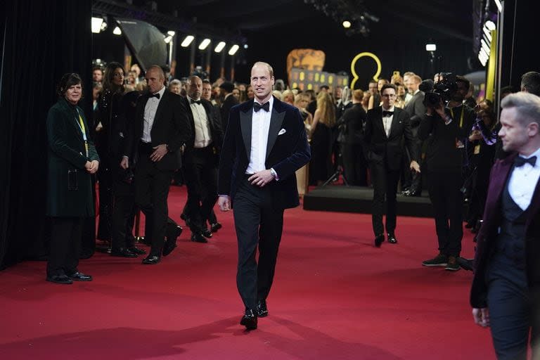 Enfundado en un traje negro con camisa blanca y moño también negro, el heredero al trono británico, el príncipe Guillermo, hace su entrada triunfal a la gala