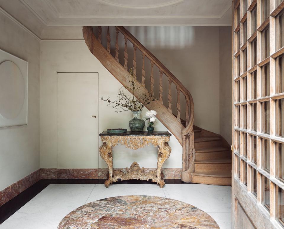 Designed by friend and longtime collaborator Axel Vervoordt, artisan painter Eddy Dankers’s three-bedroom home in Miglen, Belgium, a suburb of Antwerp, was “a canvas for me to try out pigments with a lot of depth,” he says. The 18th-century staircase in the entry foyer was the first piece Dankers purchased for the house. Its rich graining mimics the veining in the marble flooring accent, as well as the coordinating faux-marble baseboard Dankers custom-created.