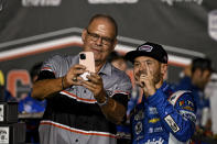 Kyle Larson, right, takes a photo with track president Kerry Tharp in Victory Lane after winning a NASCAR Cup Series auto race at Darlington Raceway, Sunday, Sept. 3, 2023, in Darlington, S.C. (AP Photo/Matt Kelley)