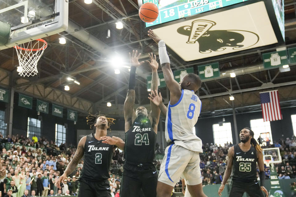 Memphis forward David Jones (8) shoots over Tulane forward Kevin Cross (24) and forward Gregg Glenn III (2) during the first half of an NCAA college basketball game in New Orleans, Sunday, Jan. 21, 2024. (AP Photo/Gerald Herbert)