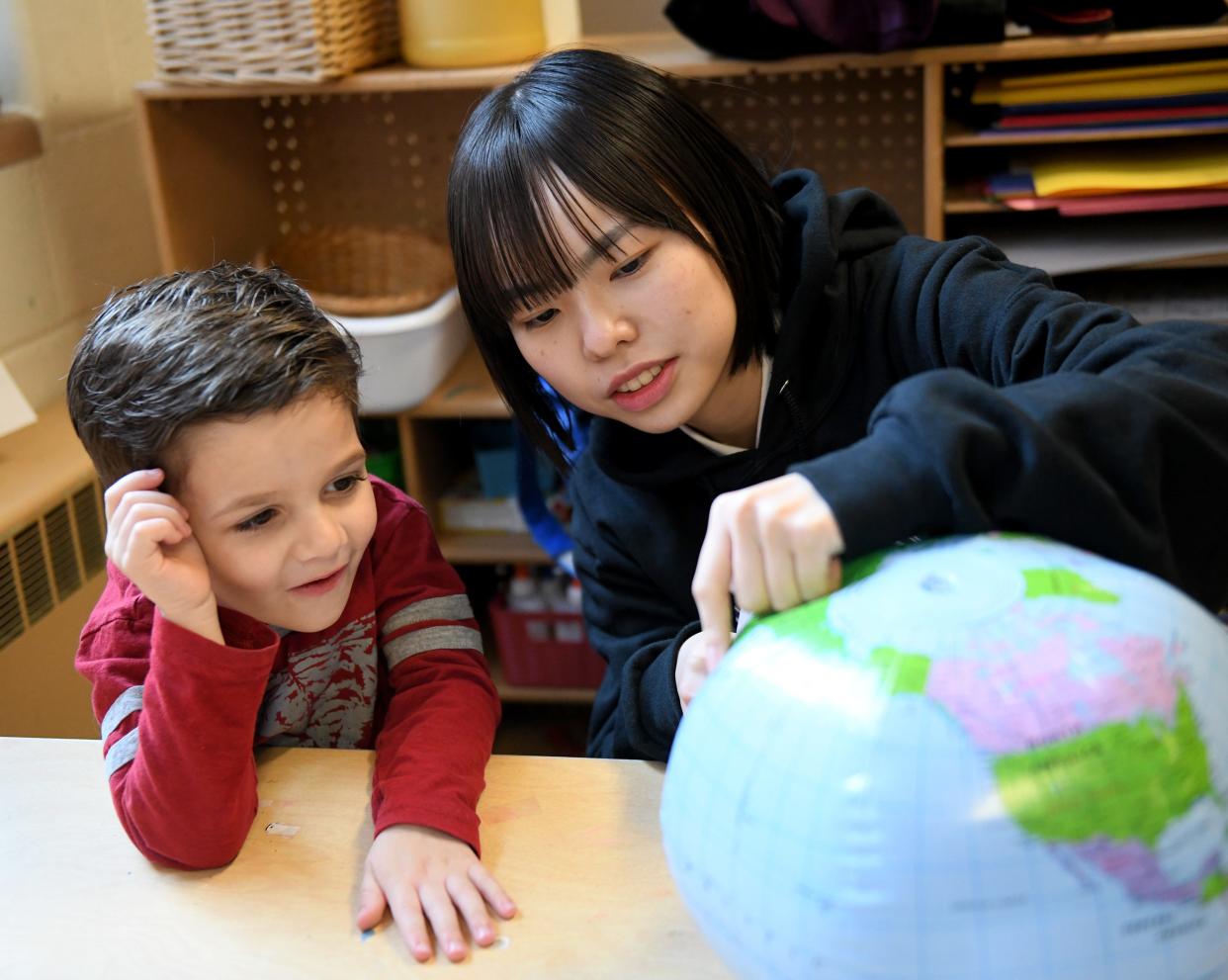 Sawa Yamashita, one of a group of Japanese students hosted by Mount Union and staying with host families shows Sammy Urso, 5, where she is from during a visit to Union Avenue United Methodist Church Preschool.    Wednesday,  March 29, 2023.