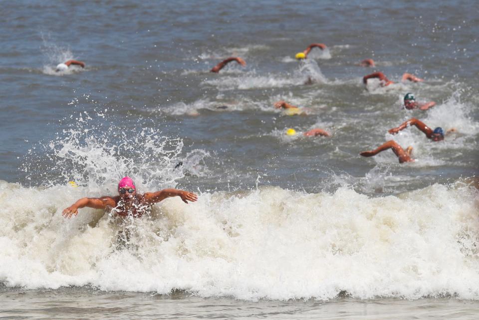 A competitor emerges from the waves in the men's surf race in the Mid-Atlantic Regional Lifeguard Championships in Rehoboth Beach Wednesday, July 13, 2022.