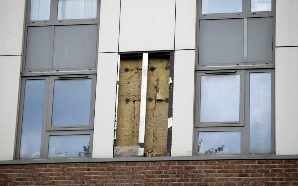 Part of the cladding is removed from a housing tower, part of the Chalcots Estate in the borough of Camden - Credit: AP