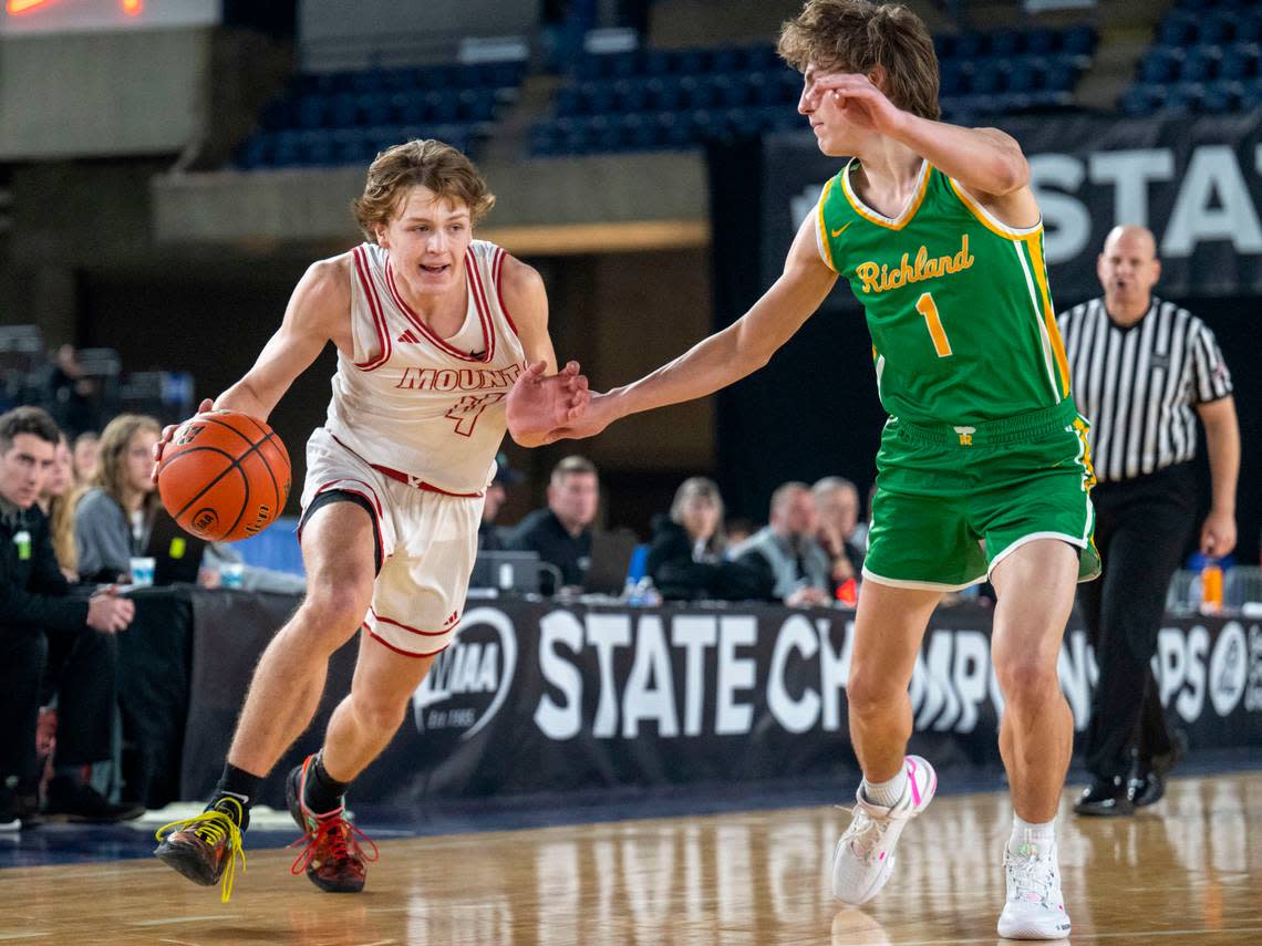 Mount Si guard Trevor Hennig (4) dribbles toward the basket as Richland guard Landen Northrop (1) defends during the first quarter of a Class 4A quarterfinal game on Thursday, March 2, 2023, in Tacoma, Wash.