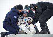 Flight engineer Sergei Ryazansky of Russia is helped out of the Soyuz TMA-10M capsule shortly after the landing in a remote area southeast of the town of Zhezkazgan in central Kazakhstan, March 11, 2014. (REUTERS/Bill Ingalls/NASA/Handout via Reuters)