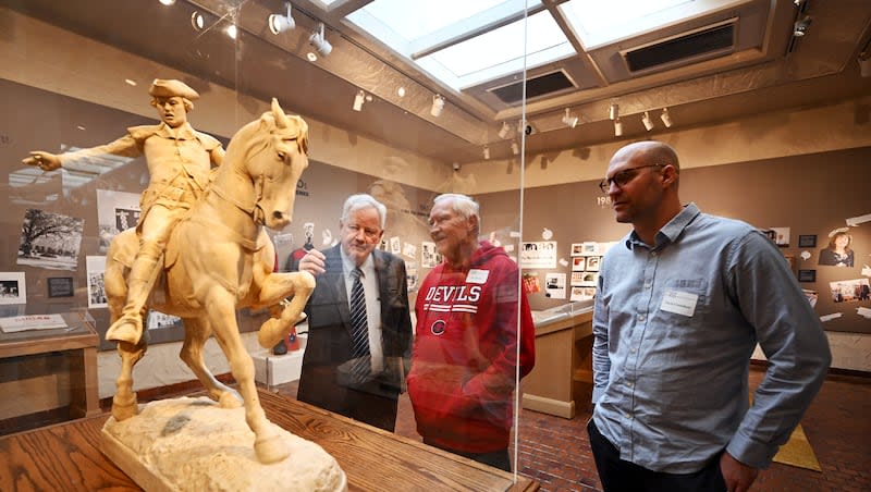 Vern Swanson, former director of the Springville Museum of Art, talks with Lee Taylor and Mark Crenshaw as they look over the many different pieces on display as the museum prepares to celebrate 100 years of the Spring Salon on Friday, April 26, 2024.