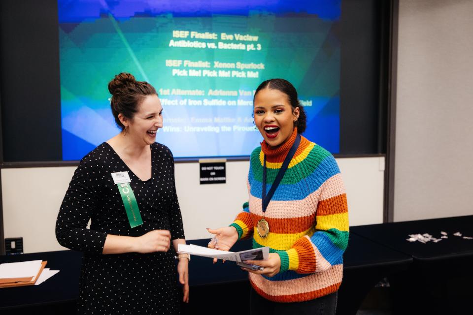 (right) Xenon Spurlock radiates joy as Cherilyn Dossett presents her with a certificate recognizing her project's selection for the International Science and Engineering Fair.