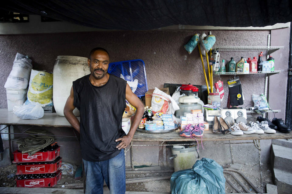In this Nov. 27, 2019 photo, Marcelin Saingiles, a store owner who sells everything ranging from cold drinks to cookies, stands in his store in Delmas, a district of in Port-au-Prince, Haiti. The 39-year-old father of three children says that he now struggles to buy milk and vegetables. (AP Photo/Dieu Nalio Chery)