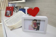 A framed photo shows Esther Melo da Silva with her grandson, in Manaus, Brazil, Tuesday, Aug. 4, 2020. The 67-year-old grandmother reported having a cold, and a few days later started having problems breathing. She died from COVID-19 on April 9, after five days in a public hospital. (AP Photo/Helton Belo)