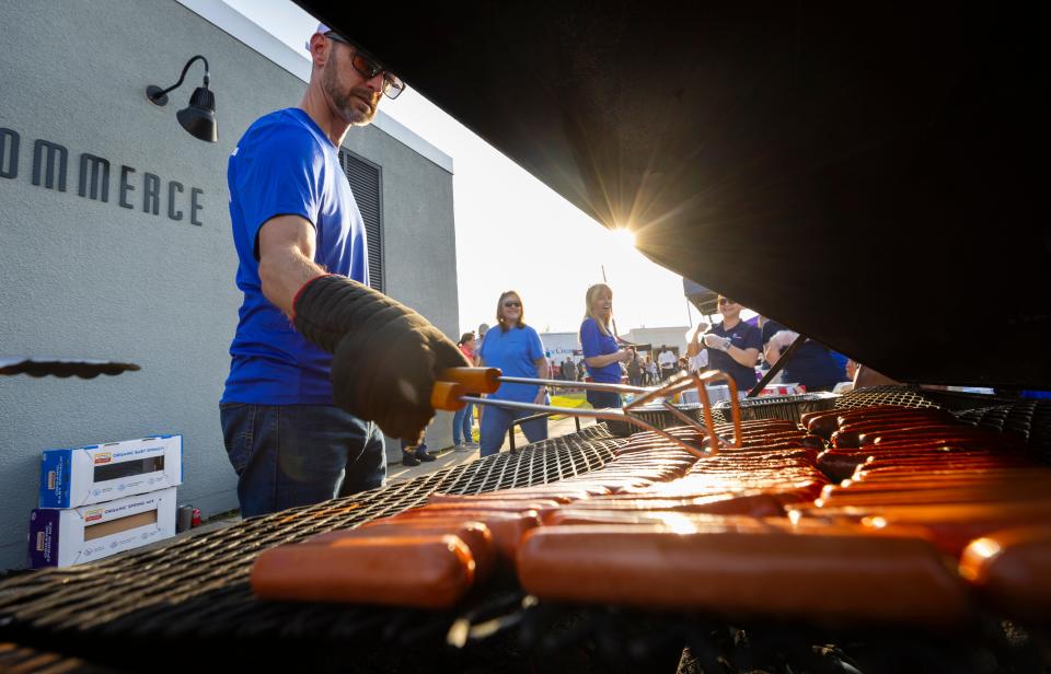 Cory Proctor cooks up some of the 400 free hot dogs handed out at the annual Bay County Chamber of Commerce block party Thursday in downtown Panama City.