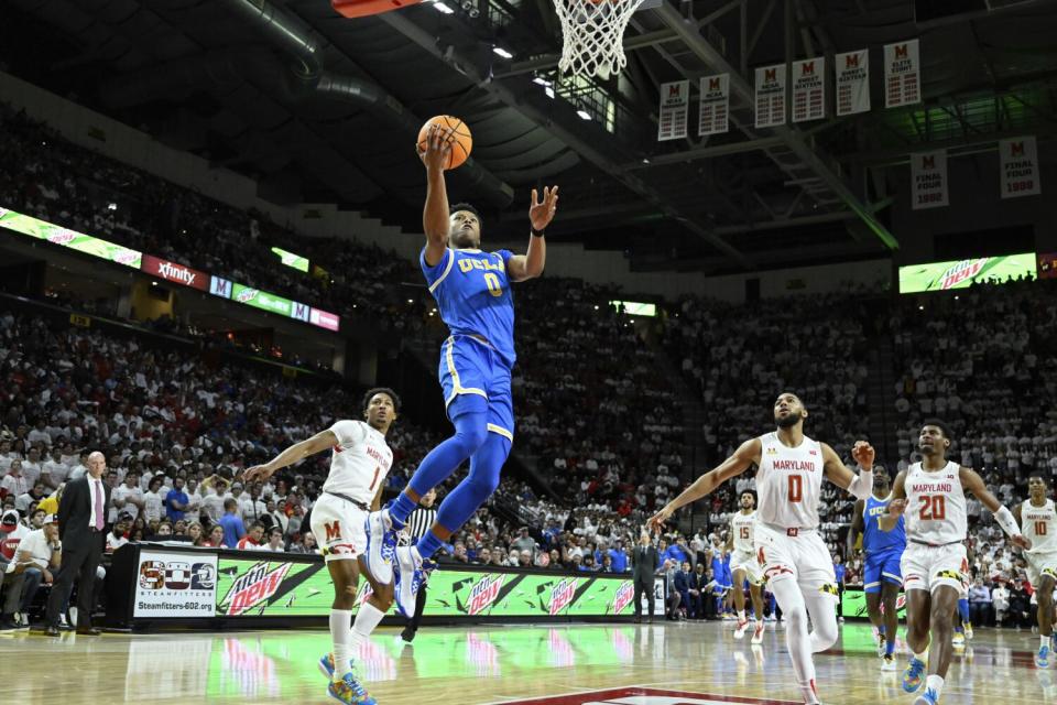 UCLA guard Jaylen Clark goes to the basket for layup and is fouled by Maryland guard Jahmir Young.