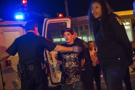 Residents are detained by police for defying a curfew in west Baltimore, Maryland, May 2, 2015. REUTERS/Adrees Latif