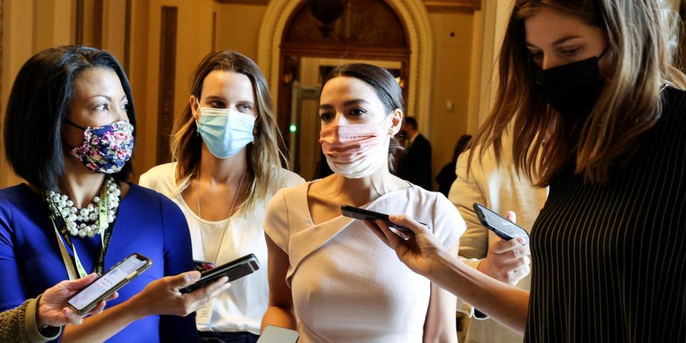 Rep. Alexandria Ocasio-Cortez talking to three reporters on Capitol Hill.