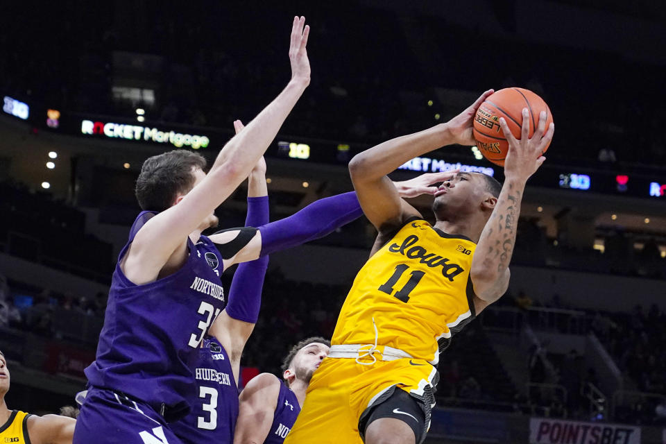 Iowa guard Tony Perkins (11) shoots over Northwestern forward Robbie Beran (31) in the first half of an NCAA college basketball game at the Big Ten Conference tournament in Indianapolis, Thursday, March 10, 2022. (AP Photo/Michael Conroy)