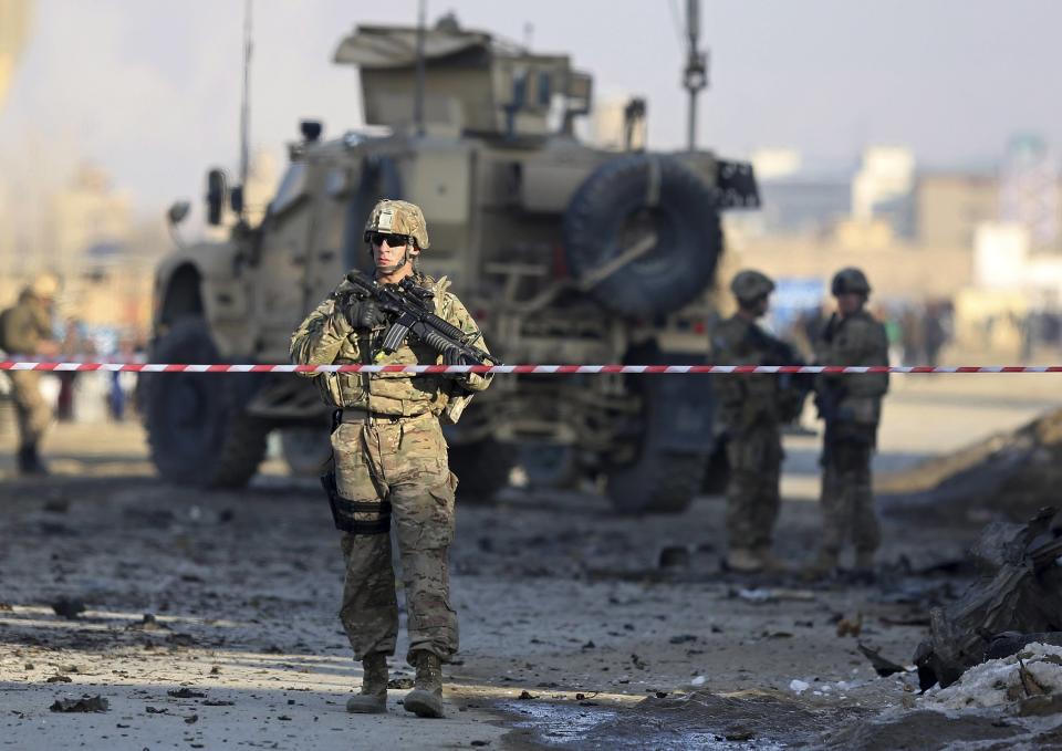 U.S. troops stand guard at the site of a suicide car bomb attack in Kabul