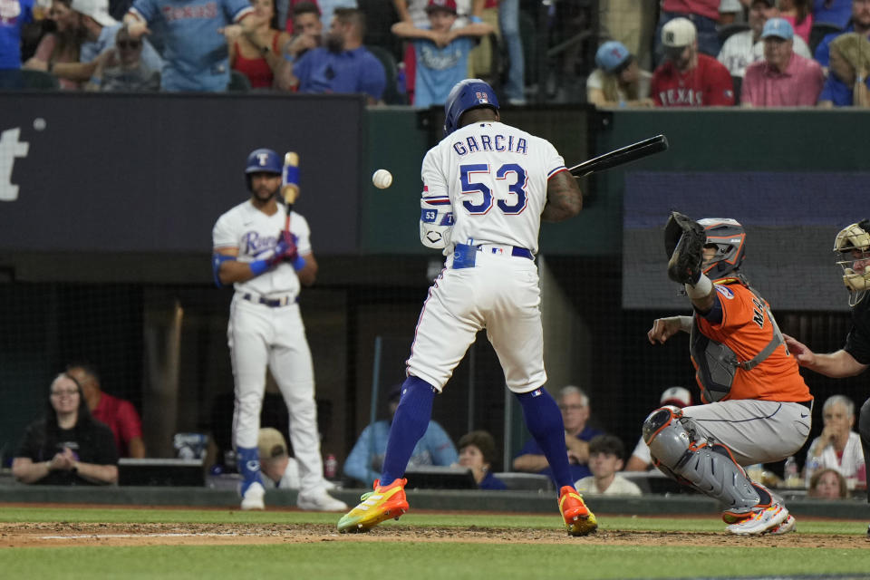 Texas Rangers' Adolis Garcia (53) is hit by a pitch thrown by Houston Astros relief pitcher Bryan Abreu during the eighth inning in Game 5 of the baseball American League Championship Series Friday, Oct. 20, 2023, in Arlington, Texas. (AP Photo/Godofredo A. Vásquez)