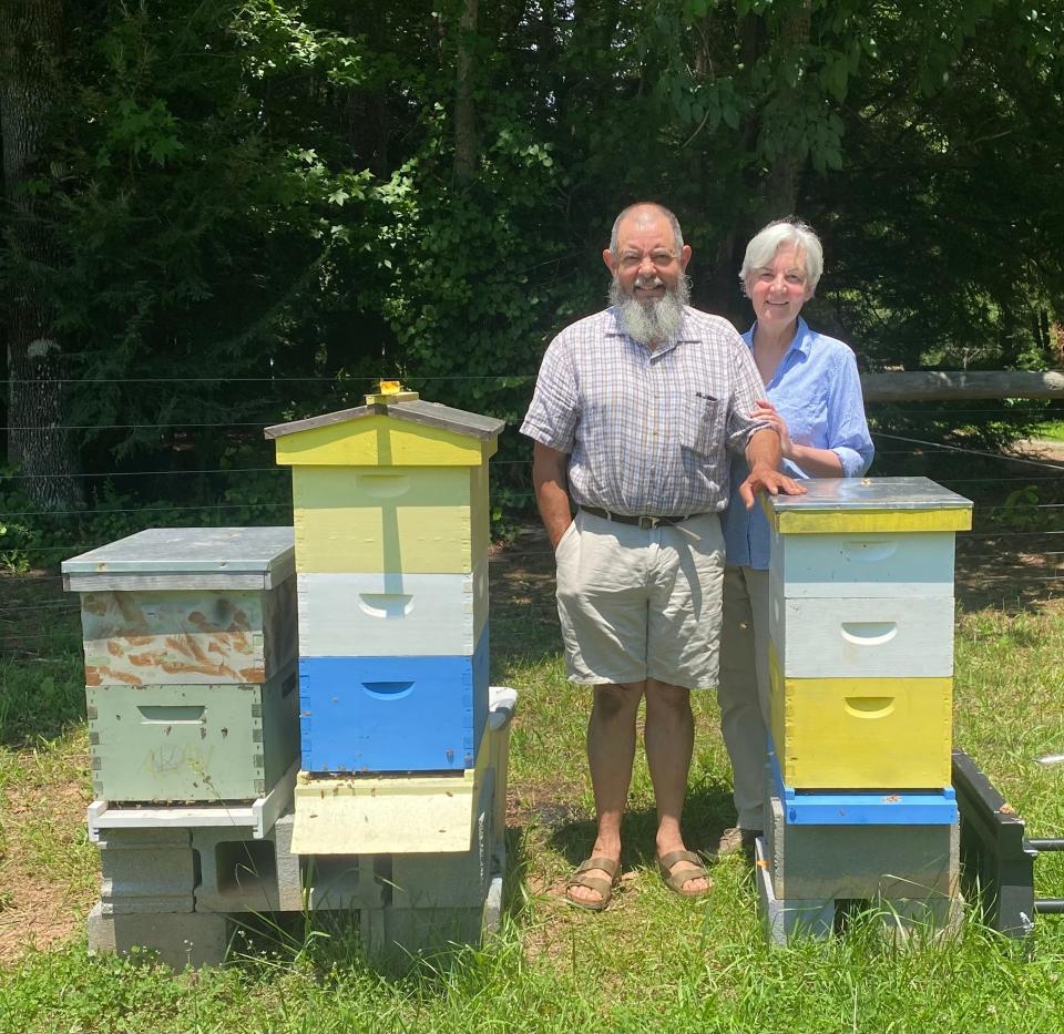 Rafael and Mary Bravo with their beehives on their farm in Polk County.
