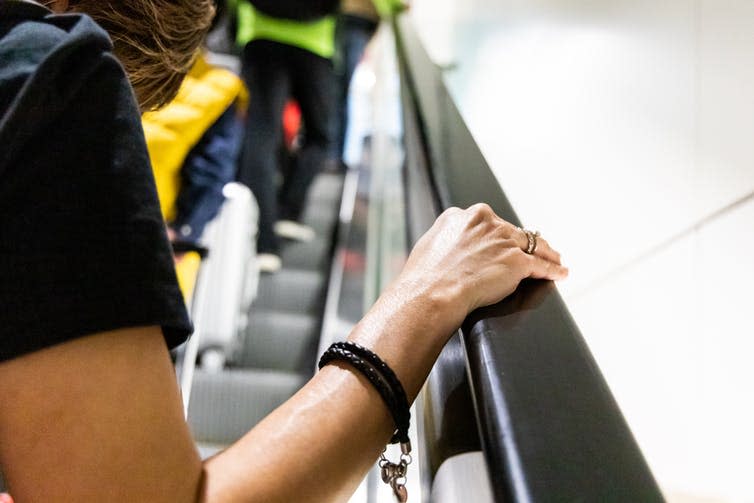 <span class="caption">How long does the virus linger on surfaces, and how might this accelerate the spread of the virus?</span> <span class="attribution"><a class="link " href="https://www.shutterstock.com/image-photo/person-holding-onto-handrail-escalator-public-1306778179" rel="nofollow noopener" target="_blank" data-ylk="slk:ThamKC/Shutterstock;elm:context_link;itc:0;sec:content-canvas">ThamKC/Shutterstock</a></span>