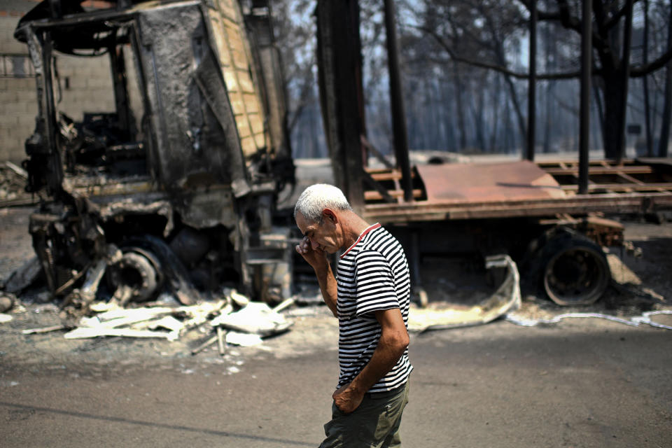 Man reacting near burned out truck