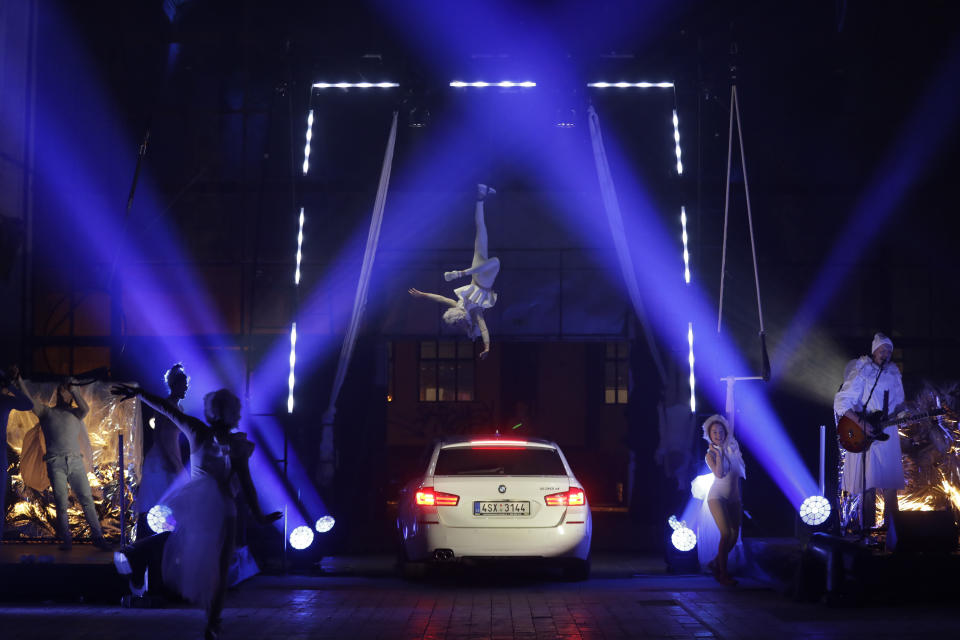 Members of the new circus company Cirk La Putyka dressed as angels, entertain people during a performance in Prague, Czech Republic, Saturday, Dec. 5, 2020. On the eve of St. Nicholas, Czechs traditionally celebrate by dressing up as Devils, Angels and St. Nicholas, and visiting children in their homes handing out small presents, coal, potatoes or other gifts. Due to the government’s restrictive measures usual traditions would be impossible. A new circus company in Prague offered a solution Saturday. They invited the kids to drive with parents their in cars through the heaven and hell they created, with devils jumping in a distance and angels flying above them. The eager visitors formed a long line of cars at the La Putyka Circus base in Prague. (AP Photo/Petr David Josek)