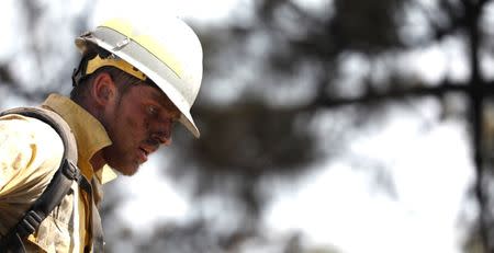 A firefighter rests while putting out hot spots during the Wilson Fire near Mount Wilson in the Angeles National Forest in Los Angeles, California, U.S. October 17, 2017. REUTERS/Mario Anzuoni