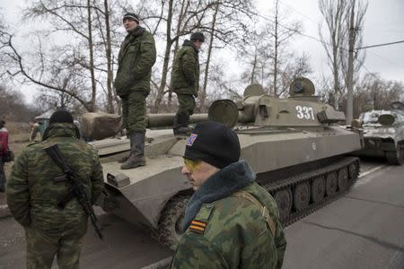 Armed men of the separatist self-proclaimed Donetsk People's Republic army sit on top of their mobile artillery cannons as they wait for a convoy to start pulling back from Donetsk February 28, 2015. REUTERS/Baz Ratner