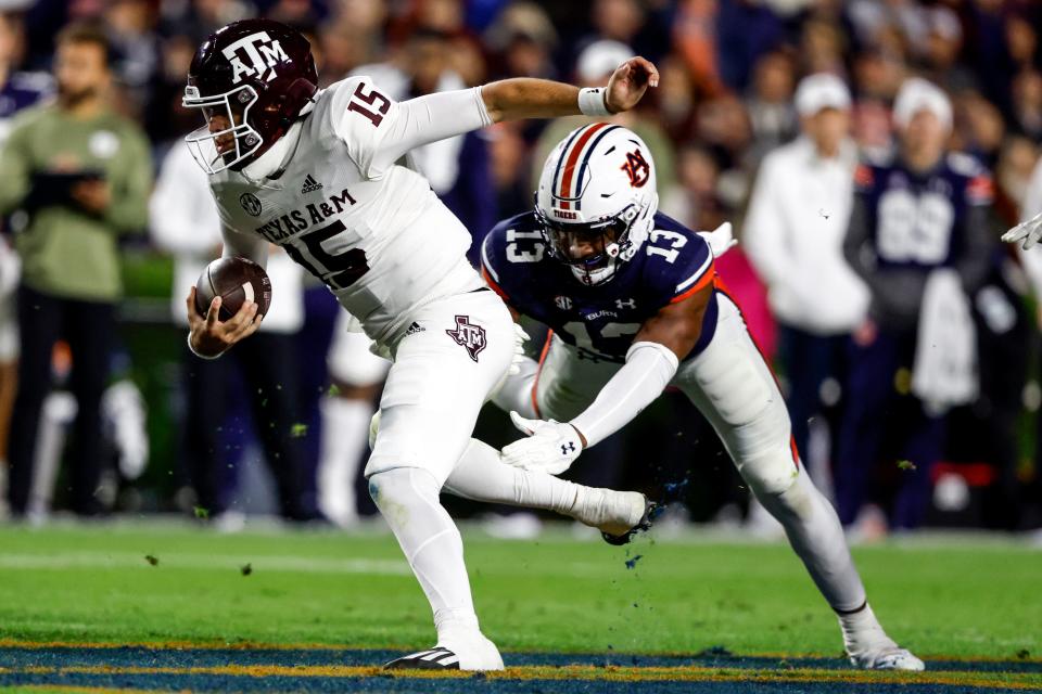 Texas A&M quarterback Conner Weigman (15) is tackled by Auburn linebacker Cam Riley (13) as he scrambles for a first down during the first half of an NCAA college football game, Saturday, Nov. 12, 2022, in Auburn, Ala. (AP Photo/Butch Dill)