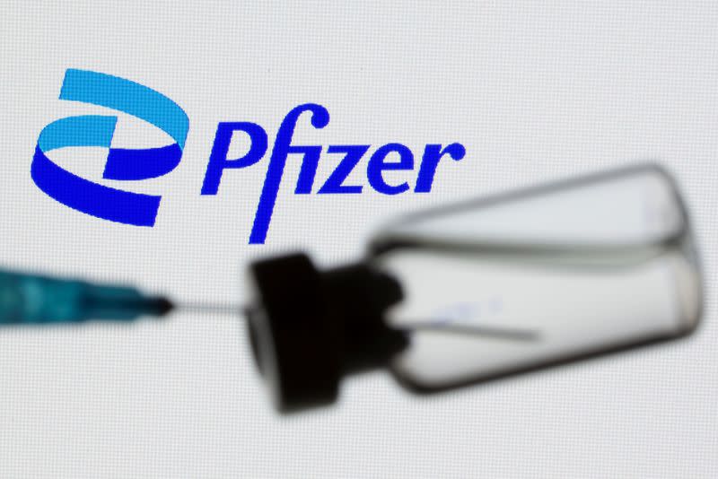 IMAGEN DE ARCHIVO. Una jeringa y un vial se ven frente al nuevo logo de Pfizer en esta ilustración tomada el 24 de junio de 2021